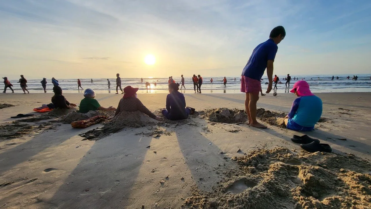 Sáng sớm, biển đã đông người. Những người đứng tuổi thường có thói quen vùi nửa mình trong cát ở những nơi thủy triều vừa rút. Theo họ, cách thức này giúp xương khớp tốt hơn.